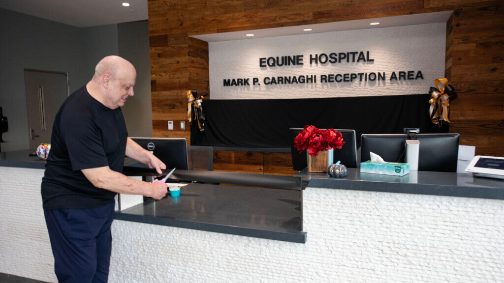 Mark Carnaghi cutting the ribbon celebrating the renaming of the Equine Hospital reception area in his honor