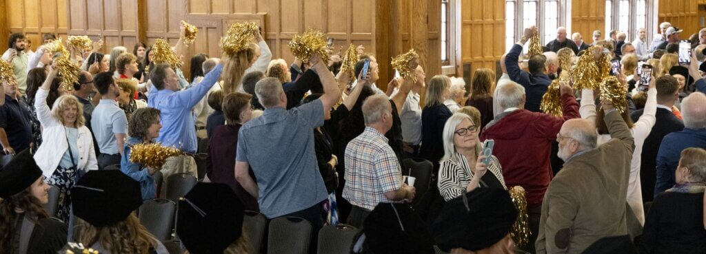 Family and friends energetically waved gold pom poms as the graduates entered.