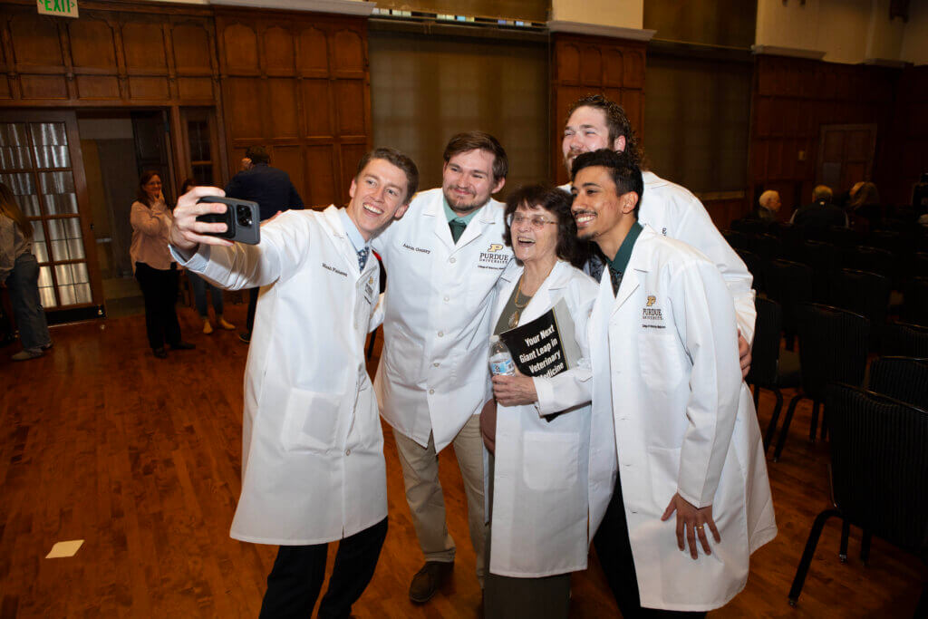 Several third year veterinary students catch a selfie with Dr. Joanne Messick – the faculty member chosen by the class to speak at the White Coat Ceremony.