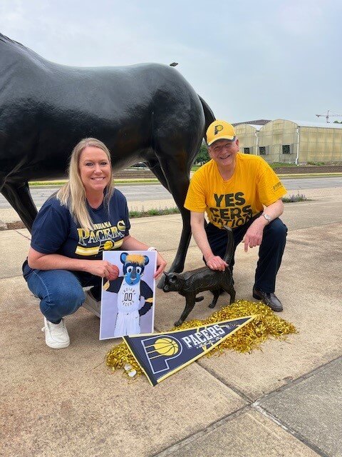 PVM staff members Andrea Kellogg and Kevin Doerr join the cat in the College of Veterinary Medicine’s Continuum sculpture in showing support for Boomer, the Pacers’ mascot.