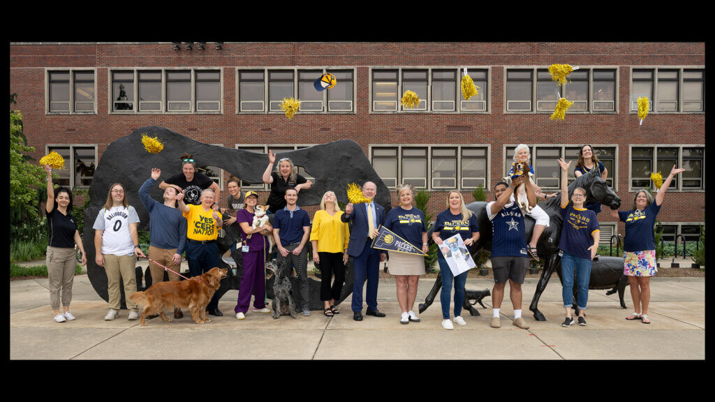 Purdue University College of Veterinary Medicine staff and faculty celebrate at the Continuum sculpture outside Lynn Hall