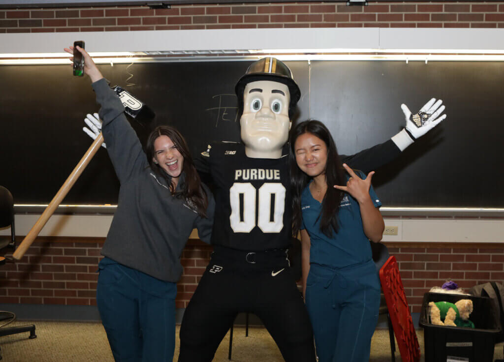 Purdue Pete makes a guest appearance as part of Launch! DVM 2029 and joins in a photo op with first-year veterinary students Carolina Chaves Trento and Bella Sung.