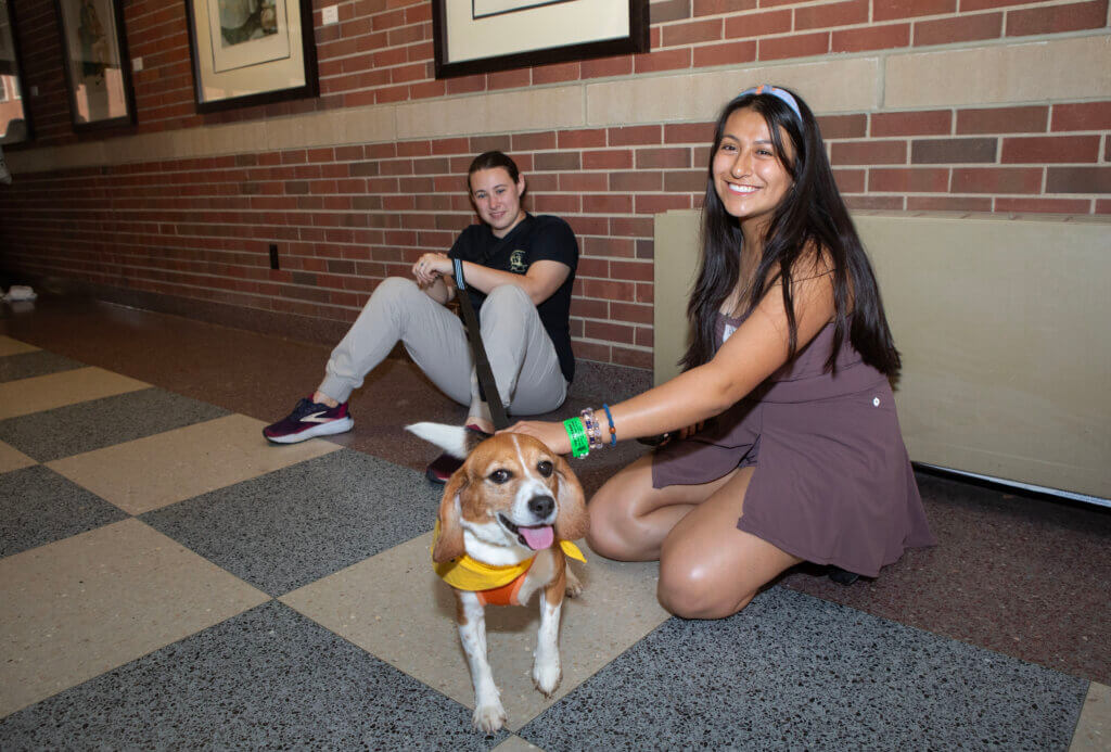 A Canine Educator helps welcome new veterinary technology student Tanya Servin-Avila.