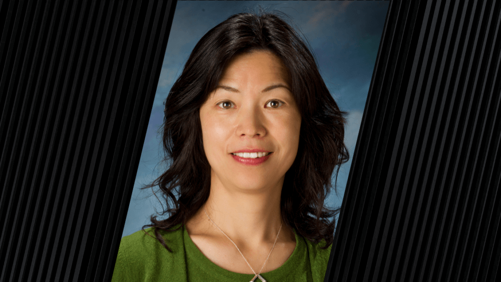 portrait of woman with long dark hair and wearing a green shirt and silver necklace