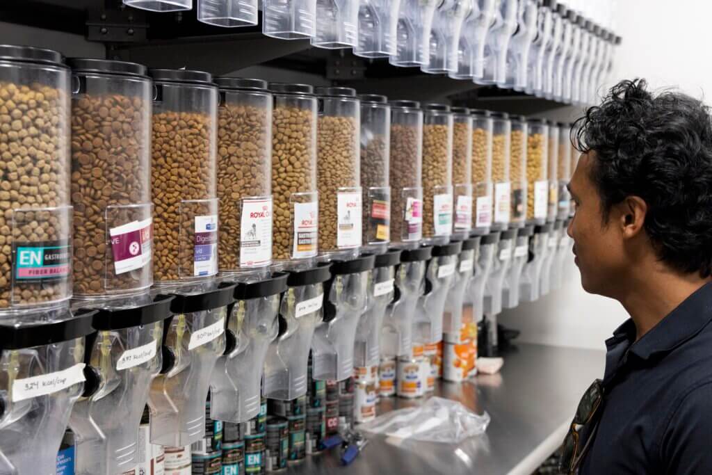 profile view of a person looking at numerous containers of pet food
