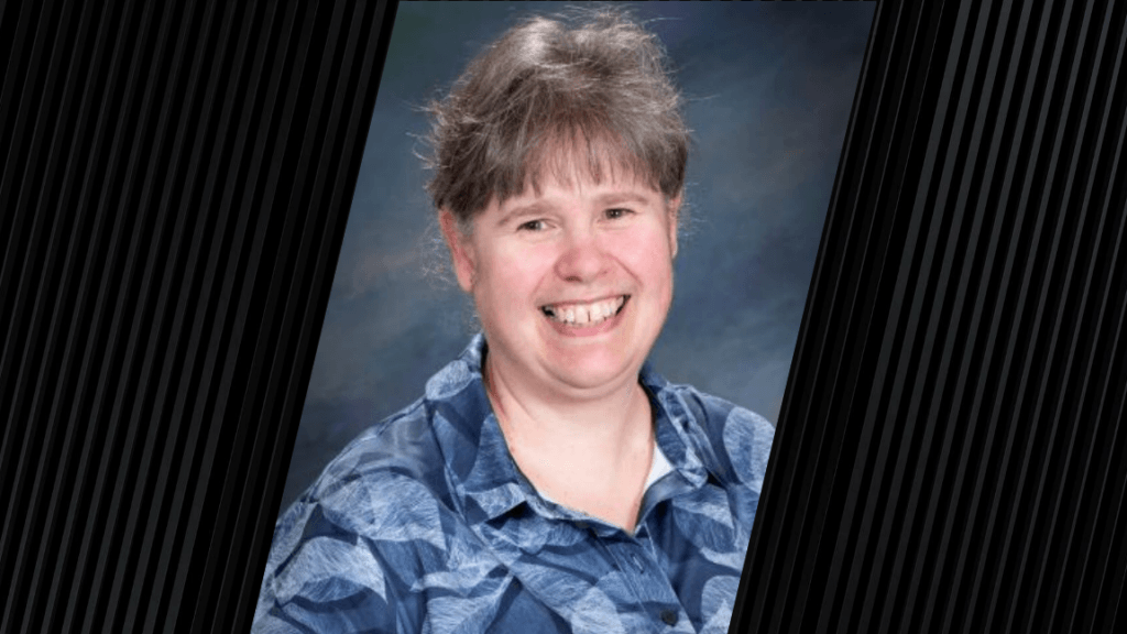 A woman is wearing a blue, floral print shirt