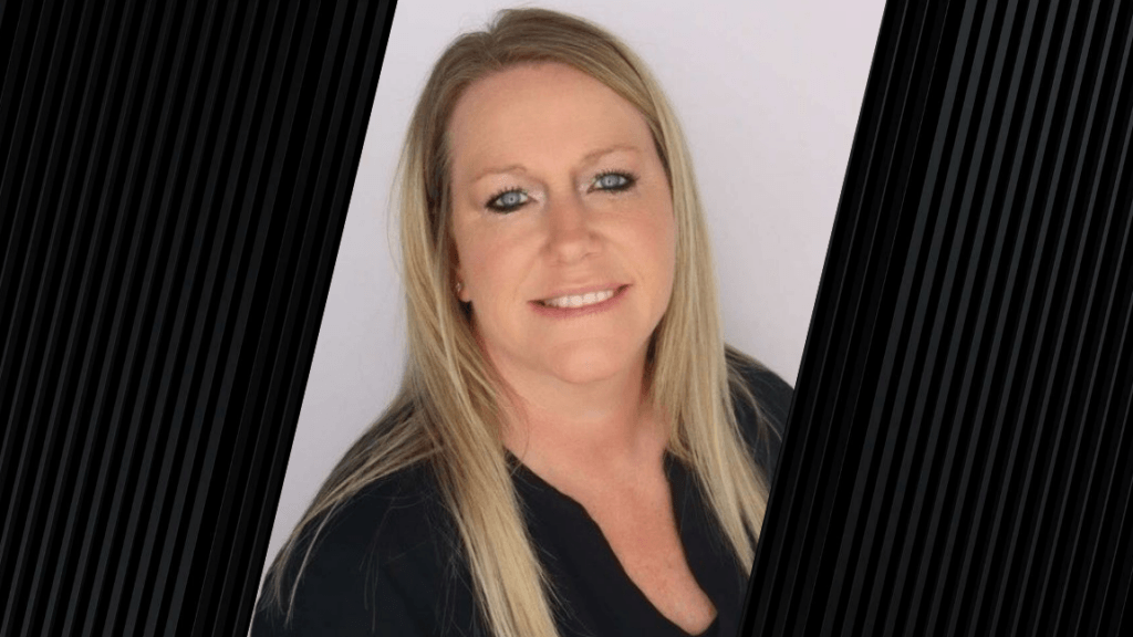 Portrait of a woman with blonde hair in front of a neutral background