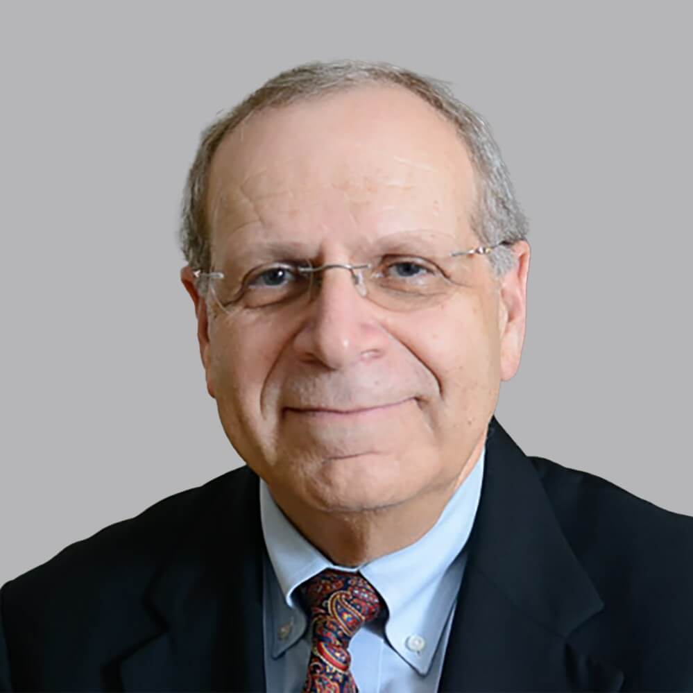 portrait of a man wearing a black jacket, blue shirt, and a tie