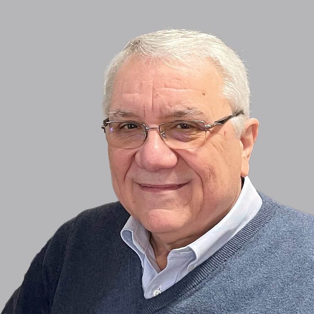 portrait of a man with white hair wearing a blue sweater