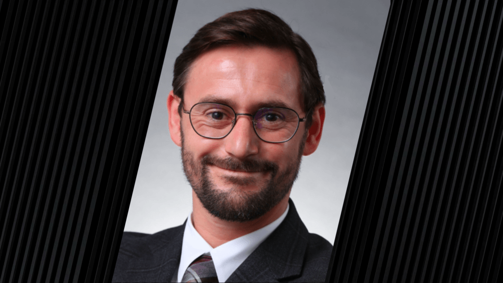 man wearing a suit jacket, glasses and a tie