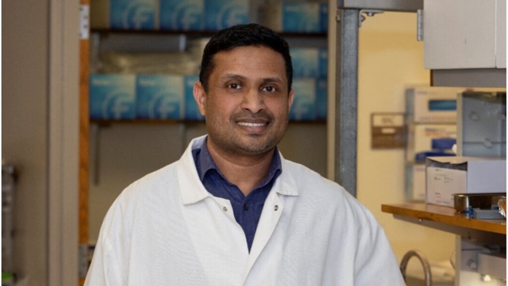 Man in a laboratory setting wearing a white coat
