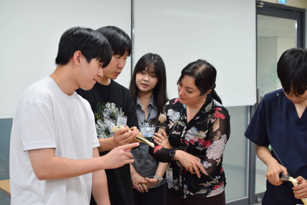 A bone is being examined by a group of adults in an academic setting.