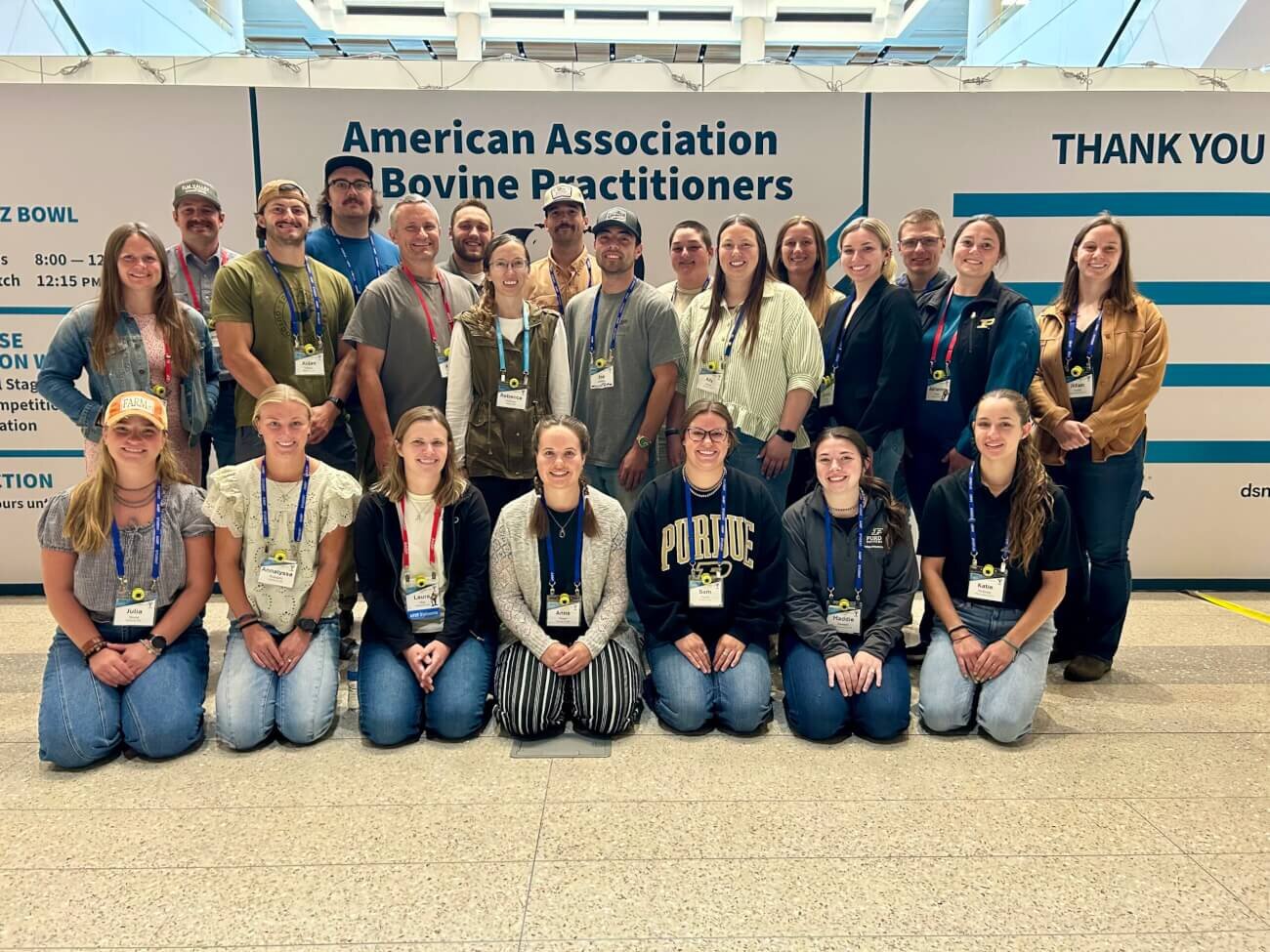 A large group of people are positioned for a photo in front of a sign that says "American Association of Bovine Practitioners"