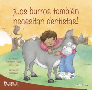 A child hugs a friendly donkey while smiling in a grassy outdoor setting.