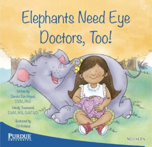 A smiling girl sits with a friendly elephant who hugs her with its trunk.