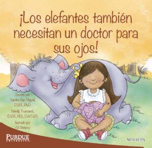 A smiling girl sits with a friendly elephant who hugs her with its trunk.