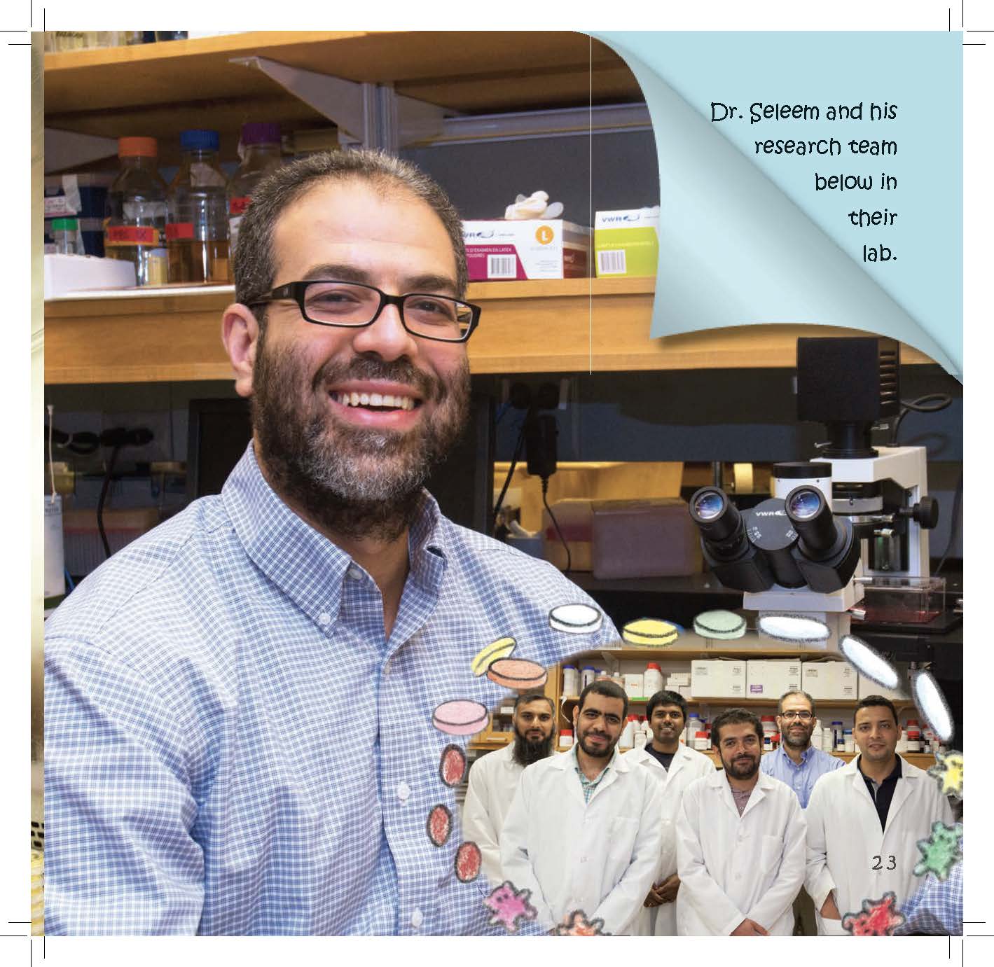 A smiling researcher stands in a laboratory with his team pictured behind him.